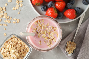 Fototapeta na wymiar Jar of tasty berry oatmeal smoothie on grey table, flat lay