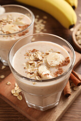 Tasty banana smoothie with oatmeal and cinnamon on wooden table