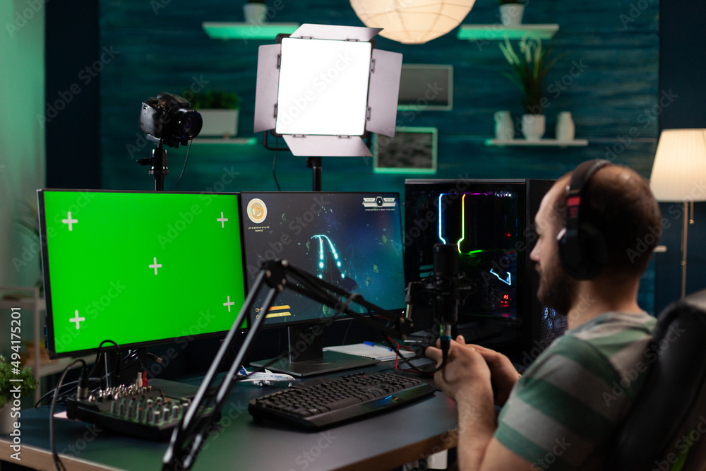 Poster man streaming video games and using horizontal green screen. person playing online games while he ha