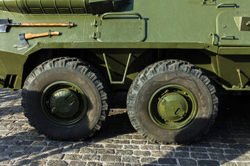 Texture of military armored vehicles. Auxiliary equipment for extinguishing fire on the side armor. Green military camouflage khaki of armored personnel carrier for transportation of manpower troops.