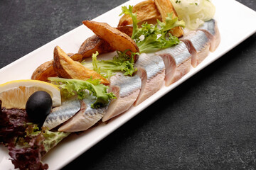 Pickled Herring with baked potatoes, onions and lettuce