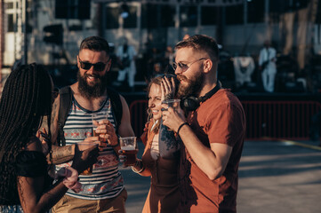 Group of friends drinking beer and having fun at music festival