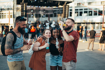 Group of friends drinking cocktails and having fun at music festival