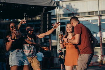 Fototapeta na wymiar Group of friends drinking beer and having fun at music festival