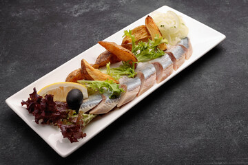 Pickled Herring with baked potatoes, onions and lettuce