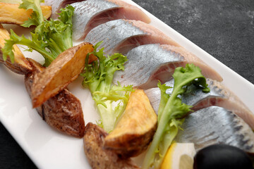 Pickled Herring with baked potatoes, onions and lettuce