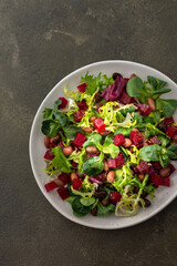 Warm salad with mixed salad with boiled beetroot and beans with spices, top view