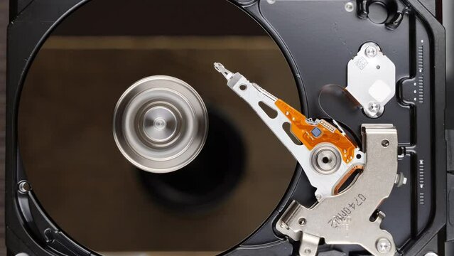 HDD spinning platter with moving read-write head. Hard disk drive starting. View from the top