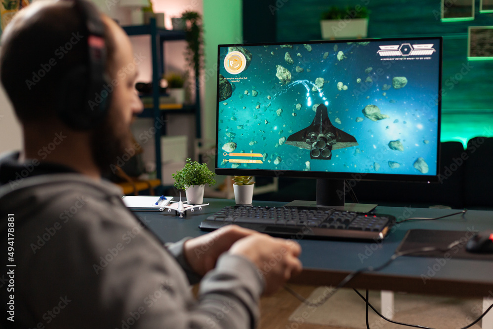 Poster gamer using headphones and joystick to play video games on computer. man playing with controller and