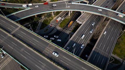 Top up aerial drone view of elevated road and traffic junctions in Chinese metropolis city Chengdu during sunny day. Modern construction design of traffic ways to avoid traffic jams. Few vehicles.