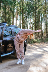 Fitness on the street travel on the road near the car on a trip.Girl doing workout in travel.Fit on the street, Health, self-care