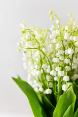 Foto auf Acrylglas Schöner Blumenstrauß aus Maiglöckchen auf weißem Hintergrund, Seitenansicht, Nahaufnahme. Grußkarte, Frühlingshintergrund. Vertikal © Dina Photo Stories