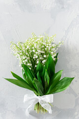 Bouquet of flowers lily of the valley on white background. Flat lay, top view with copy space. Greeting card mockup for Mother's Day, Woman's Day