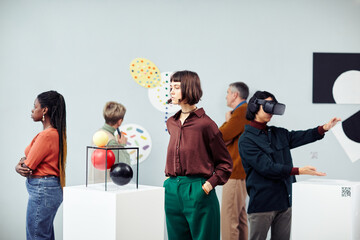 Group of diverse multi-ethnic young and senior people looking at contemporary art objects at exhibition in modern gallery - obrazy, fototapety, plakaty