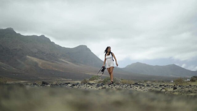 Slow motion young female freelancer photographer taking photo in remote landscape natural wilderness mountains in canary island Spain
