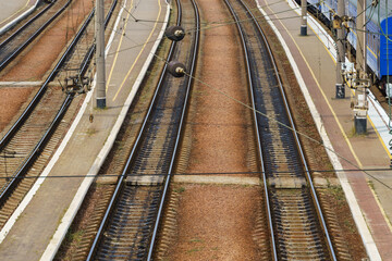 view of the infrastructure of the railway station - rails, platform and passenger railcars, without people