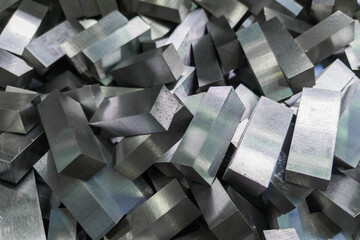 a pile of shiny faceted steel blocks - full frame close-up with selective focus