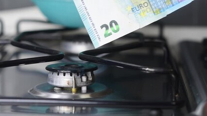 Gas price increase concept: slow motion of a 20 euro banknote burnt on a lit stove - Powered by Adobe