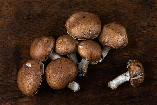 White mushrooms, Paris mushrooms, champignon on brown and brown wooden background and texture.