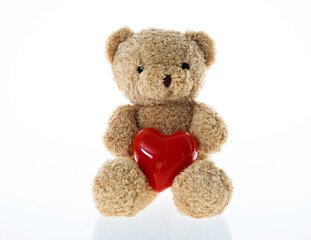 Teddy bear holding a red heart against white background