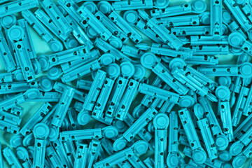 Many blue disposable diabetes lancets used to draw blood for testing