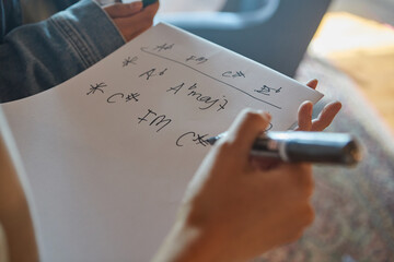 close up of a person writing music chords on a paper