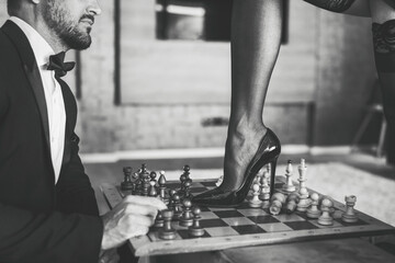 Sexy woman leg in stockings and high heels steps into chess board black and white