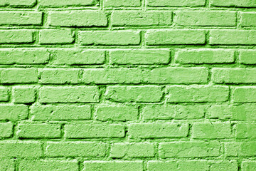 Green paint brick wall. Abstract color home facade background. Decorative artistic urban construction. Eco color street design texture. Bright vibrant wall pattern.