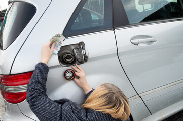 Woman preparing money for filling the tank. Gas price rise concept