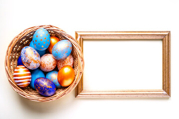 colored golden, blue, blue Easter eggs on a yellow background for Easter in a basket