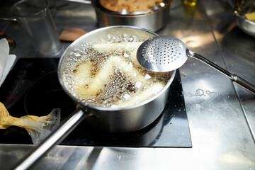 churros are fried in boiling oil in a frying pan. Wet the boiling oil with a sponge in the pan....