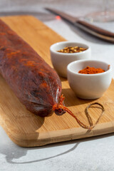 Kulen on wooden cutting board. Meat sausage made of minced pork with red paprika, traditionally produced in Croatia and Serbia.