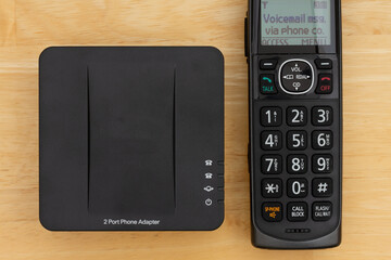 VOIP 2 port phone adapter and phone on a desk