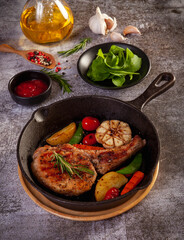 Fried pork steak in frying pan, close up view.