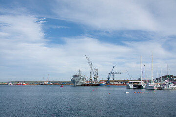Fototapeta premium cranes and ships along side the loading bays at Birkenhead docks blue sea and sky seascape no people nobody