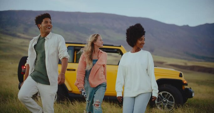 Three friends walking through beautiful field exploring and living their best life on summer road trip, freedom and travel lifestyle