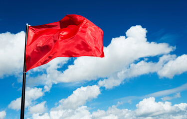 Fototapeta na wymiar Red flag waving against blue sky