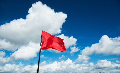 Red flag waving against blue sky