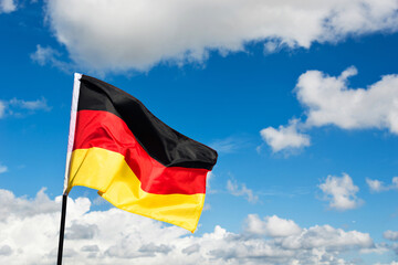 German flag waving against blue sky