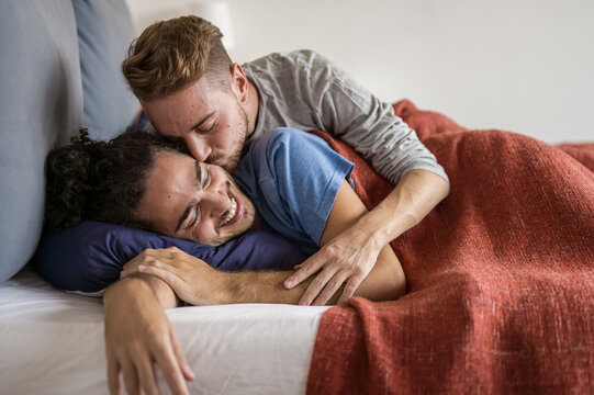 Tender awakening of a gay man kissing his boyfriend, daily moments of a LGBT couple