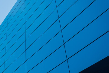 Geometric colored building facade elements with planes, lines and corners with light flare and reflections for an abstract background and texture of white, blue, gray colors. Place for text