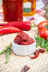pepper on a beautiful ground among greens and pepper paste on a serving plate