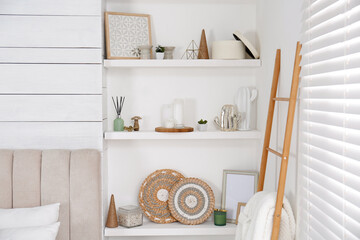Fototapeta na wymiar Wall shelves with beautiful decor elements indoors. Interior design