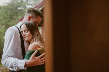 Close-up portrait newlyweds embracing standing in the wooden house in evening. Wedding day.