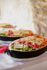 des crudités dans un plat lors d'un apéritif avec radis, carottes, choux fleur, courgettes