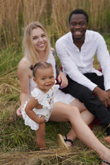 Fototapeta premium Multiracial happy family of father mother and their daughter