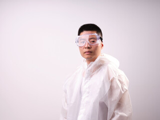 A health care worker wearing a mask and protective clothing on a solid color background
