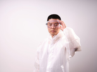 A health care worker wearing a mask and protective clothing on a solid color background