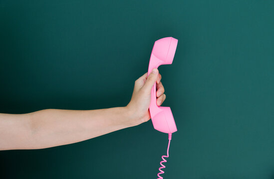 Woman Hand Holding Vintage Telephone Receiver Isolated On Green Background