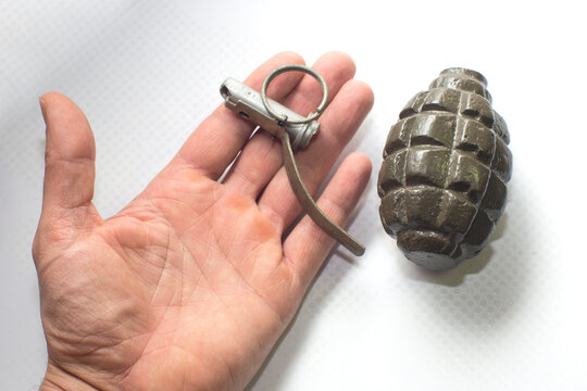 broken army training grenade on the palm, isolated background